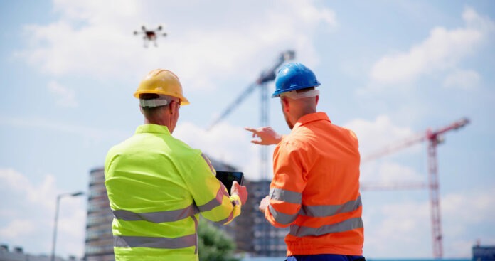 Zwei Männer überprüfen die Lage auf einer Baustelle.