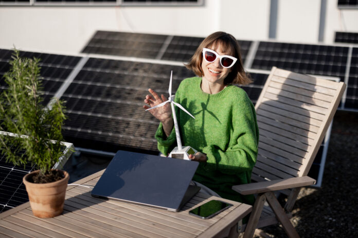 Eine Frau mit einer Mini-Wind-Anlage und Solarpanel.