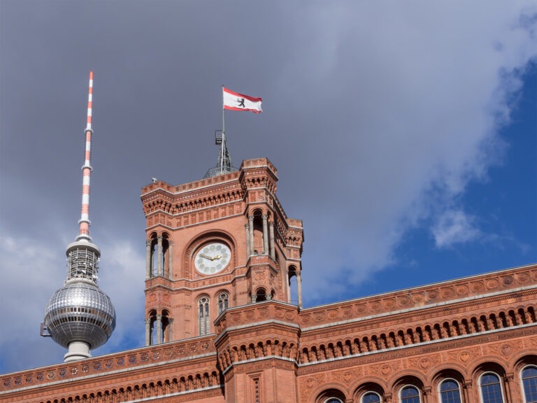 Das berühmte Rote Rathaus in Berlin, mit dem Fernsehturm im Hintergrund.