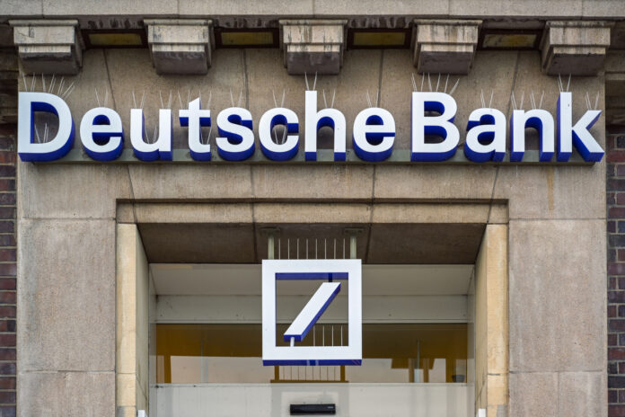 Der Eingang einer Filiale der Deutschen Bank mit dem charakteristischen Logo darüber.