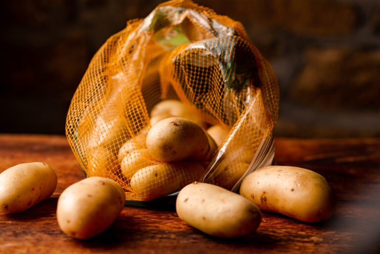 Ein Sack mit Kartoffeln liegt auf dem Tisch.