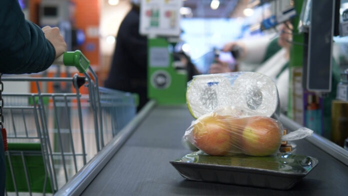 Produkte liegen auf einem Kassenband an der Kasse in einem Discounter oder Supermarkt.