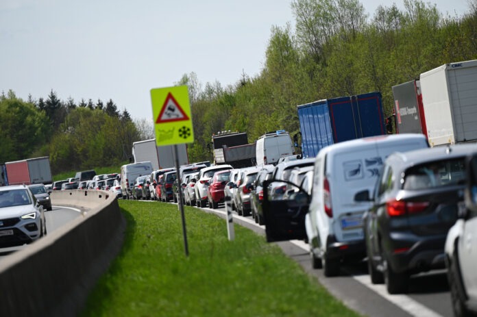 Ein langer Stau mit vielen Fahrzeugen im Sommer auf der Autobahn.