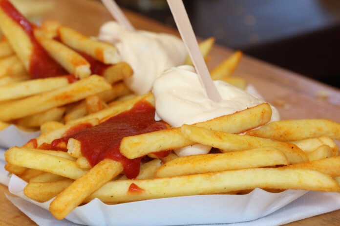 Zwei Portionen Pommes Frites mit Mayo und Ketchup.