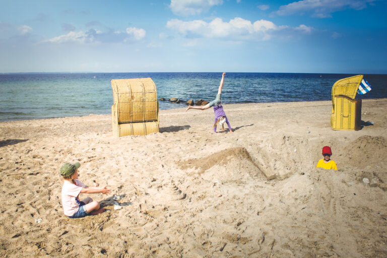 Ein Strand mit wenig Touristen, an dem Kinder am spielen.