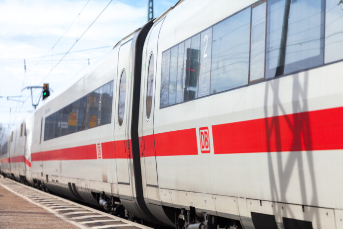 Die Deutsche Bahn hat einen Zug mit mehreren Wagons an einem Bahnsteig geparkt.