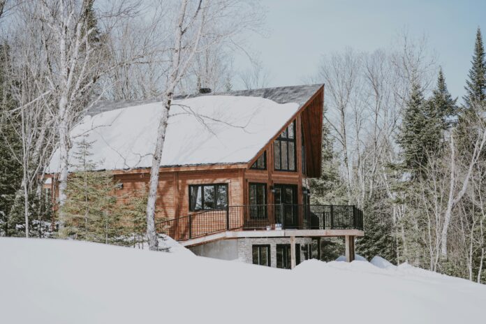 Holzhaus mit Terrasse in einem verschneiten Wald